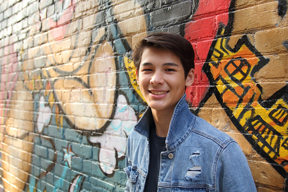 Young man on graffiti wall in Old Town Lansing, Michigan