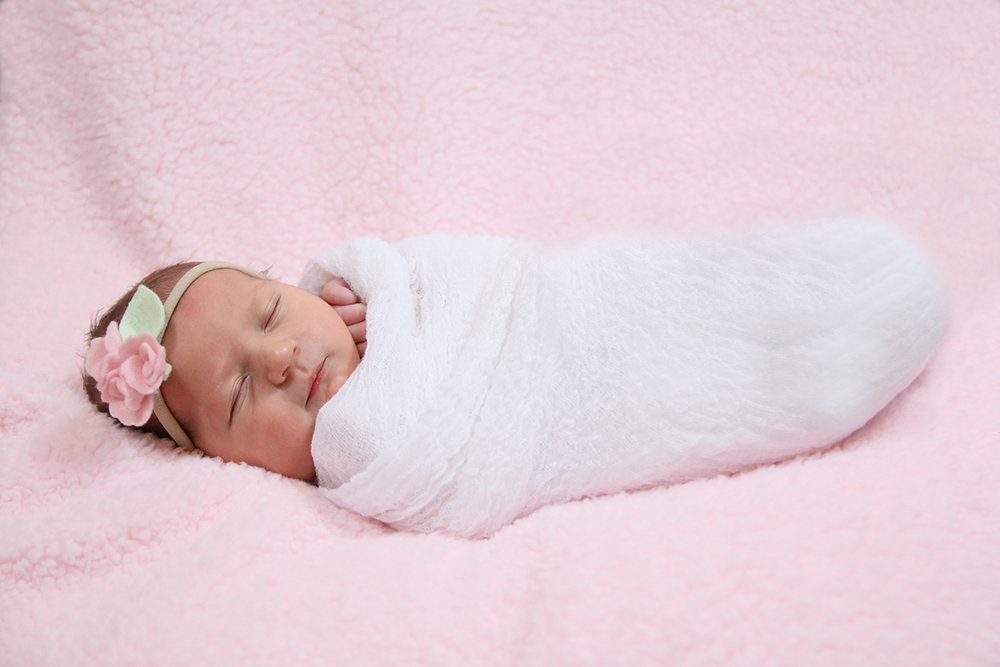 Newborn baby girl wrapped in pink