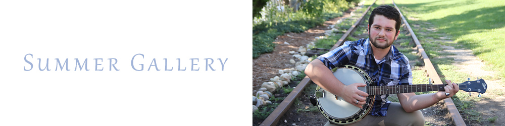 young man playing a guitar on an abandoned rail road track in Old Town Lansing Michigan