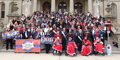Women dressed like Rosie the Riveter at the Michigan State Capitol for National Rosie the Riveter Day