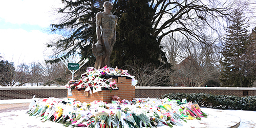 flowers laying atThe Rock after a gun man shot three MSU students