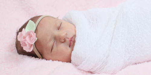 Newborn baby girl wrapped in pink