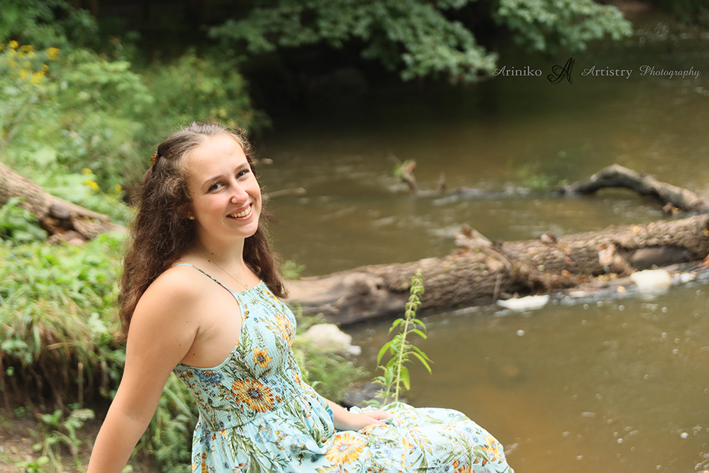 young female High school senior posing in Town Charlotte, Michigan for her senior portraits