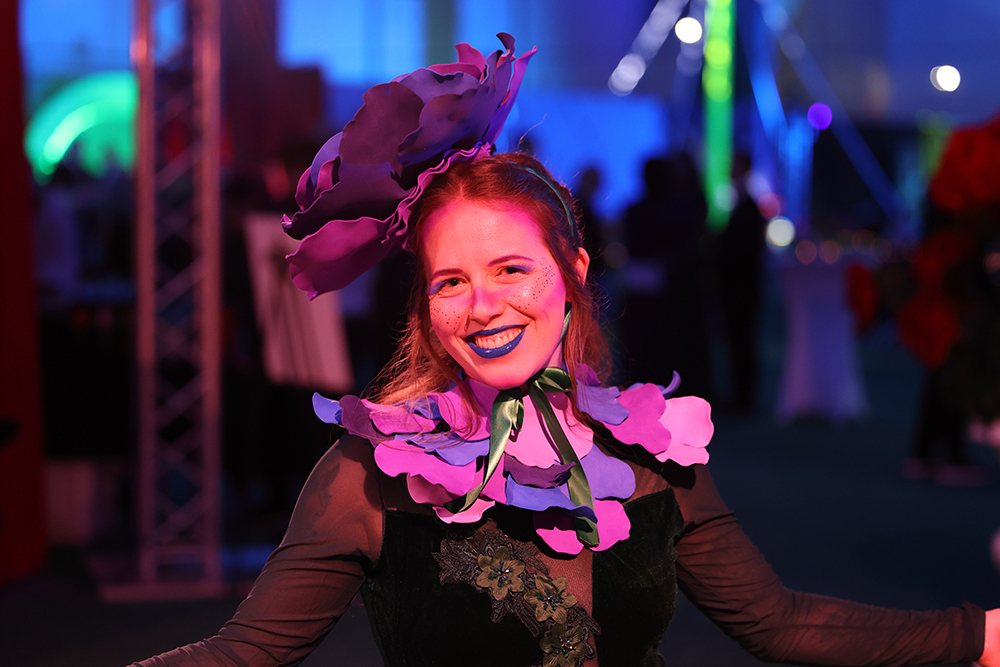 Young woman dressed in Alice in Wonderland attire performing at the U of M Sparrow Gala
